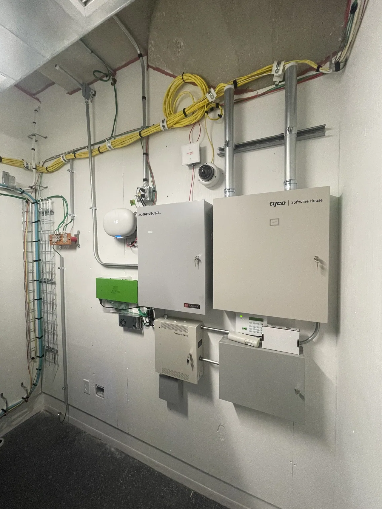 Wall-mounted commercial systems equipment with cable pathways and conduit.